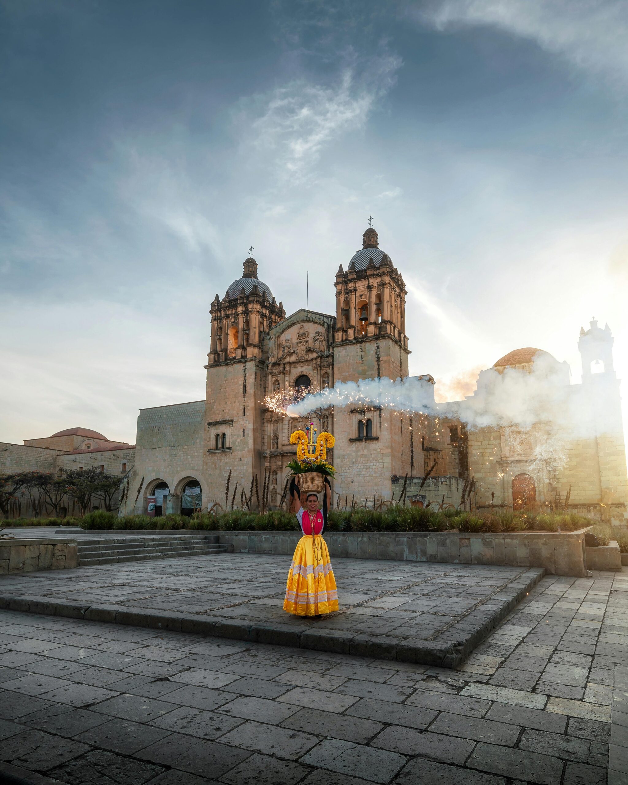 Woman in traditional attire dances at Santo Domingo Church in Oaxaca, Mexico.
